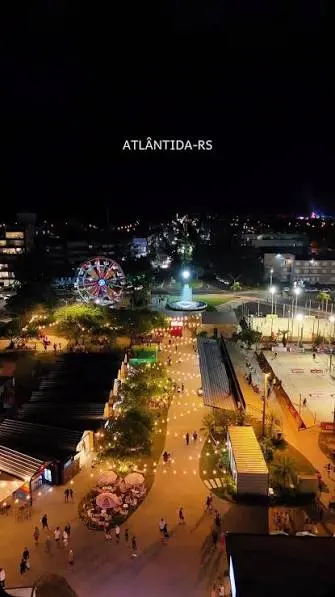 Vista noturna de espaço de passeio e gastronomia em Atlântida.